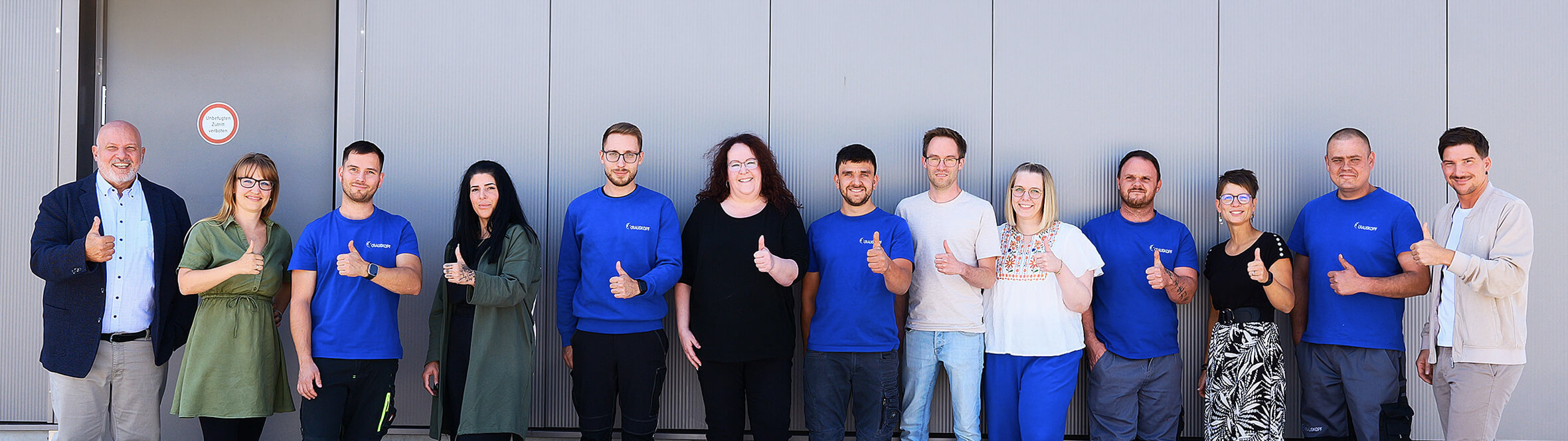 Team steht in einer Reihe und macht Daumen hoch